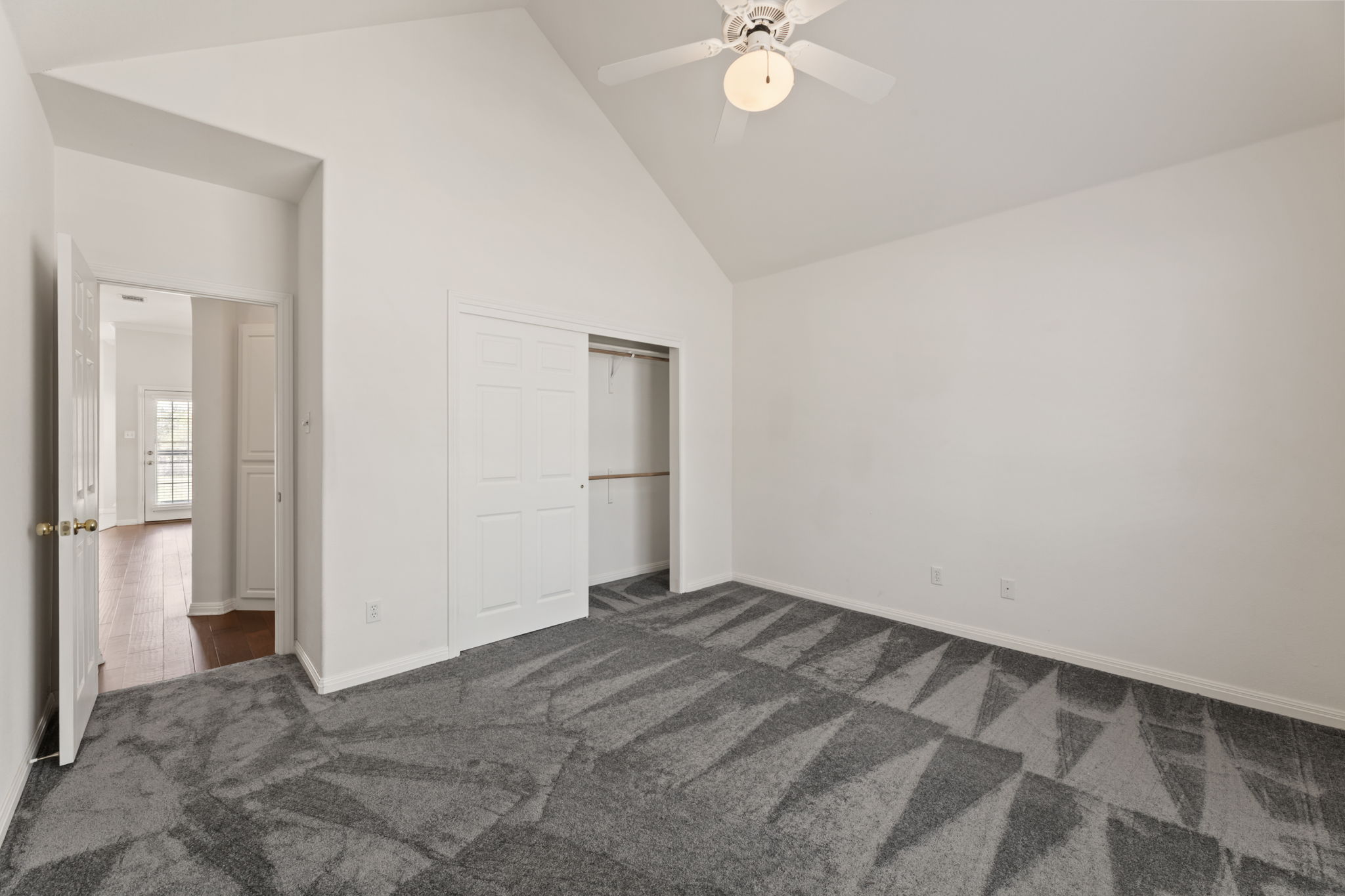 109 Riverview Drive Georgetown, TX 78628 - Photo 18 of 35 Unfurnished bedroom featuring a closet, vaulted ceiling, dark colored carpet, and a ceiling fan