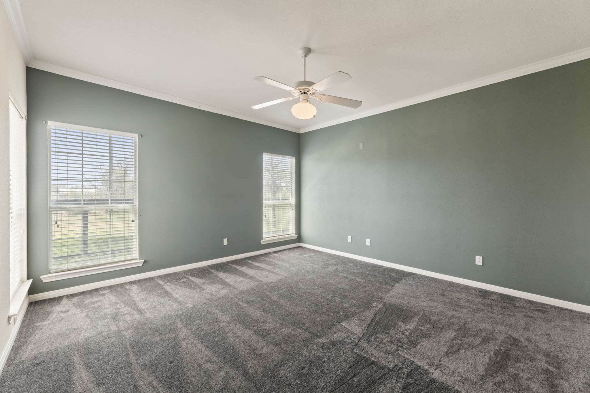 109 Riverview Drive Georgetown, TX 78628 - Photo 20 of 35 Empty room featuring crown molding, dark carpet, and ceiling fan