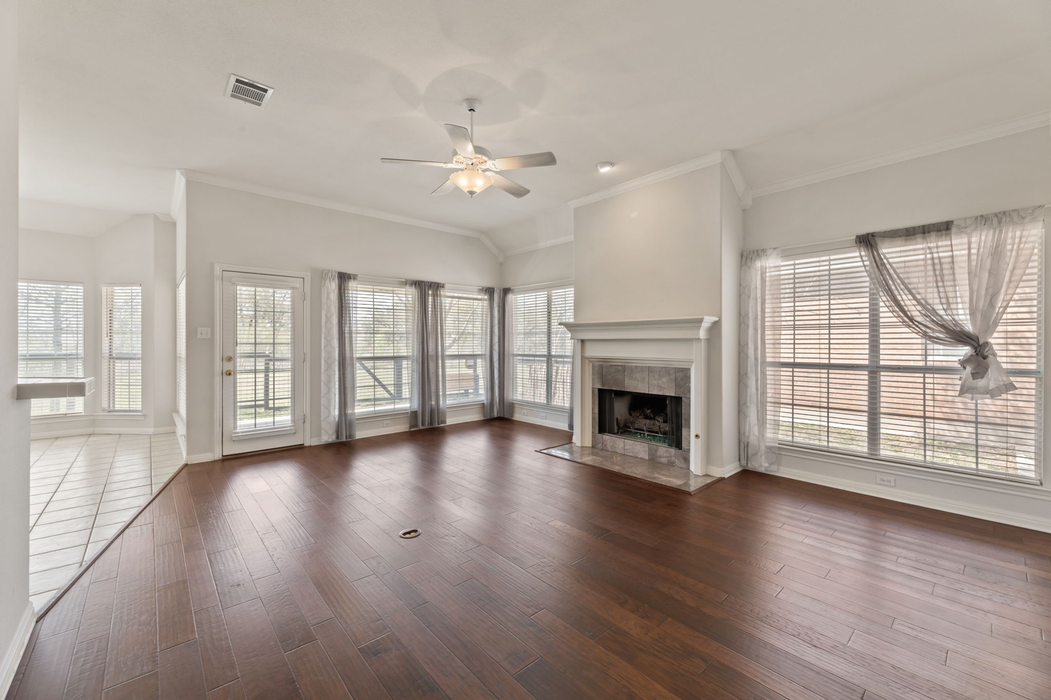 109 Riverview Drive Georgetown, TX 78628 - Photo 9 of 35 Unfurnished living room with a ceiling fan, ornamental molding, dark wood-type flooring, plenty of natural light, and vaulted ceiling