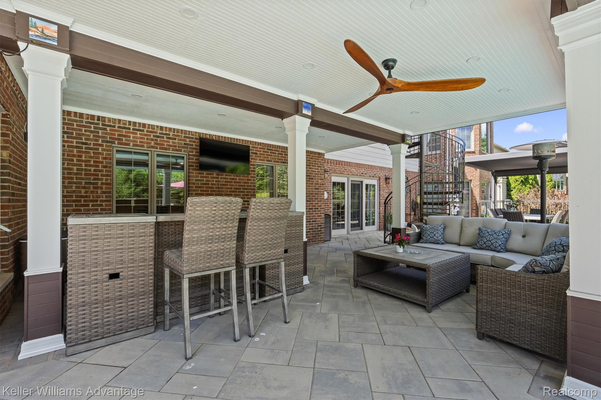 22878 Tree Top Court South Lyon, MI 48178 - Photo 53 of 75 Covered outdoor patio featuring a bluestone tile floor, a ceiling fan with wood-finish blades, and a brick exterior wall