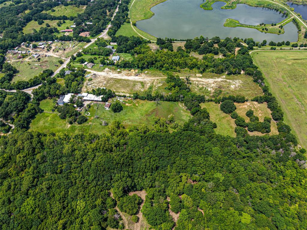 1900 Haymarket Road Dallas, TX 75253 - Photo 13 of 20 Expansive aerial perspective showcasing diverse terrain including wooded areas, open fields, and a significant body of water
