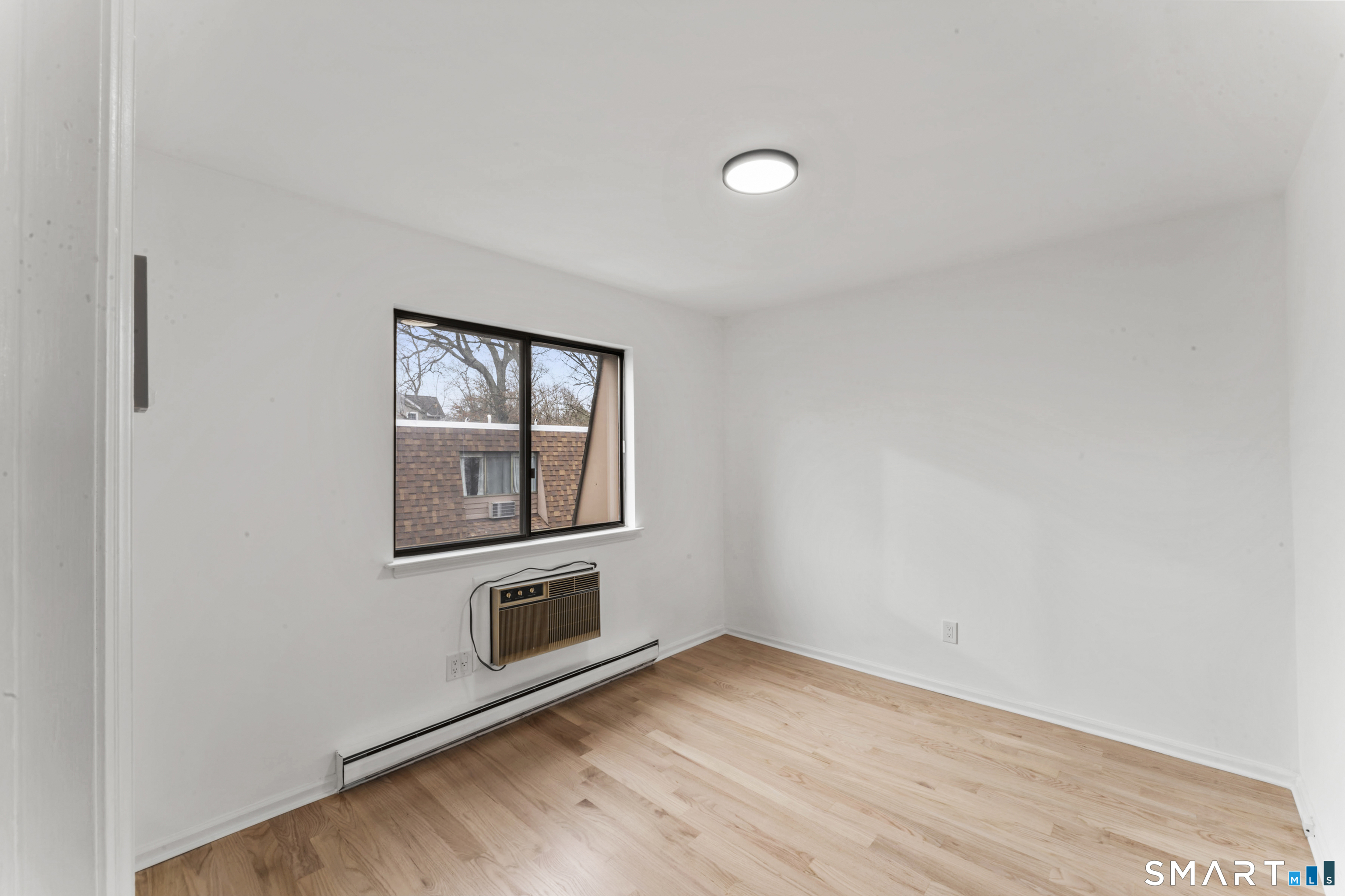 100 Maple Tree Avenue, Unit 7 Stamford, CT 06906 - Photo 18 of 38 a view of a livingroom with wooden floor and a flat screen tv