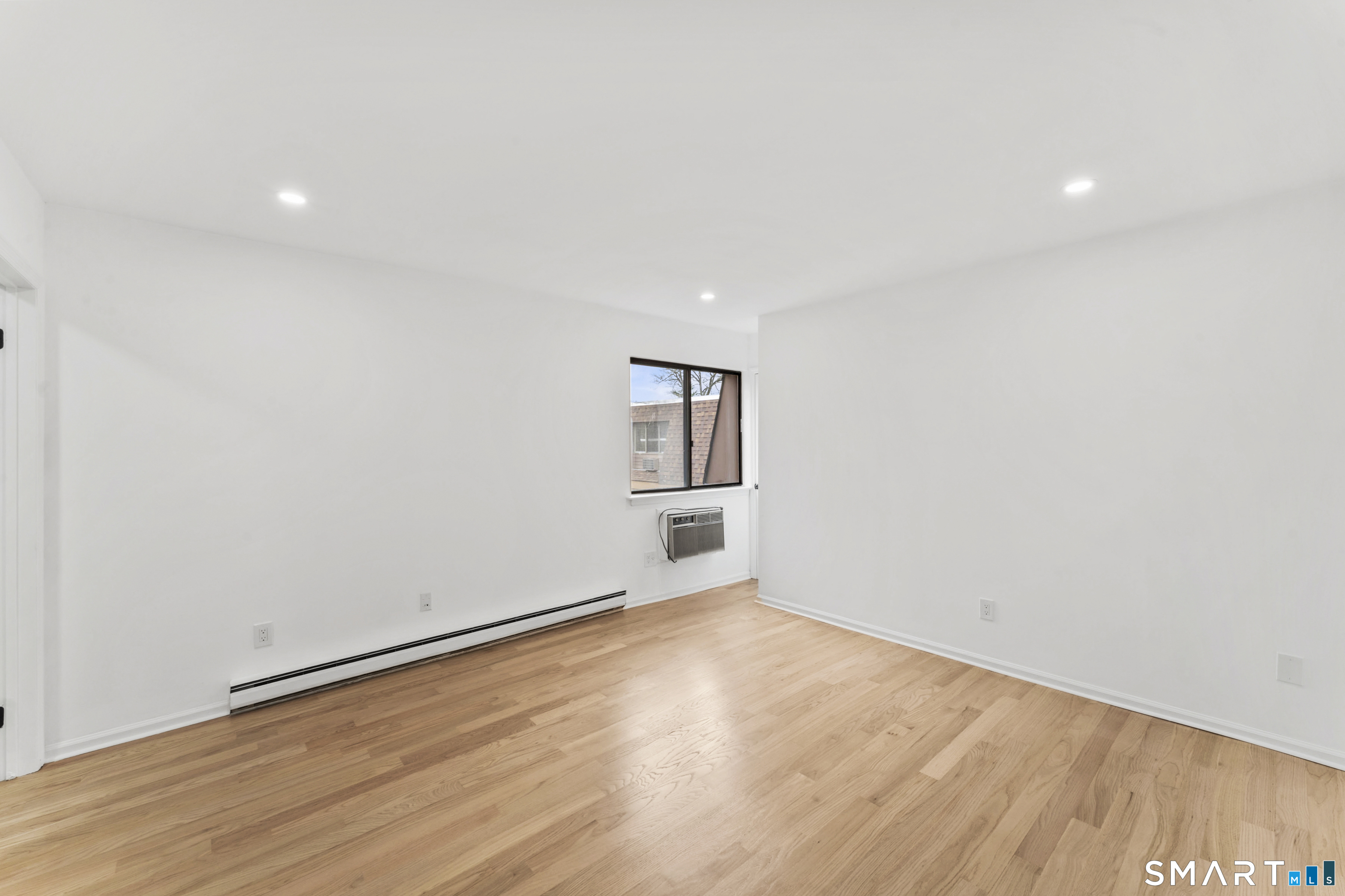 100 Maple Tree Avenue, Unit 7 Stamford, CT 06906 - Photo 24 of 38 an empty room with wooden floor and windows