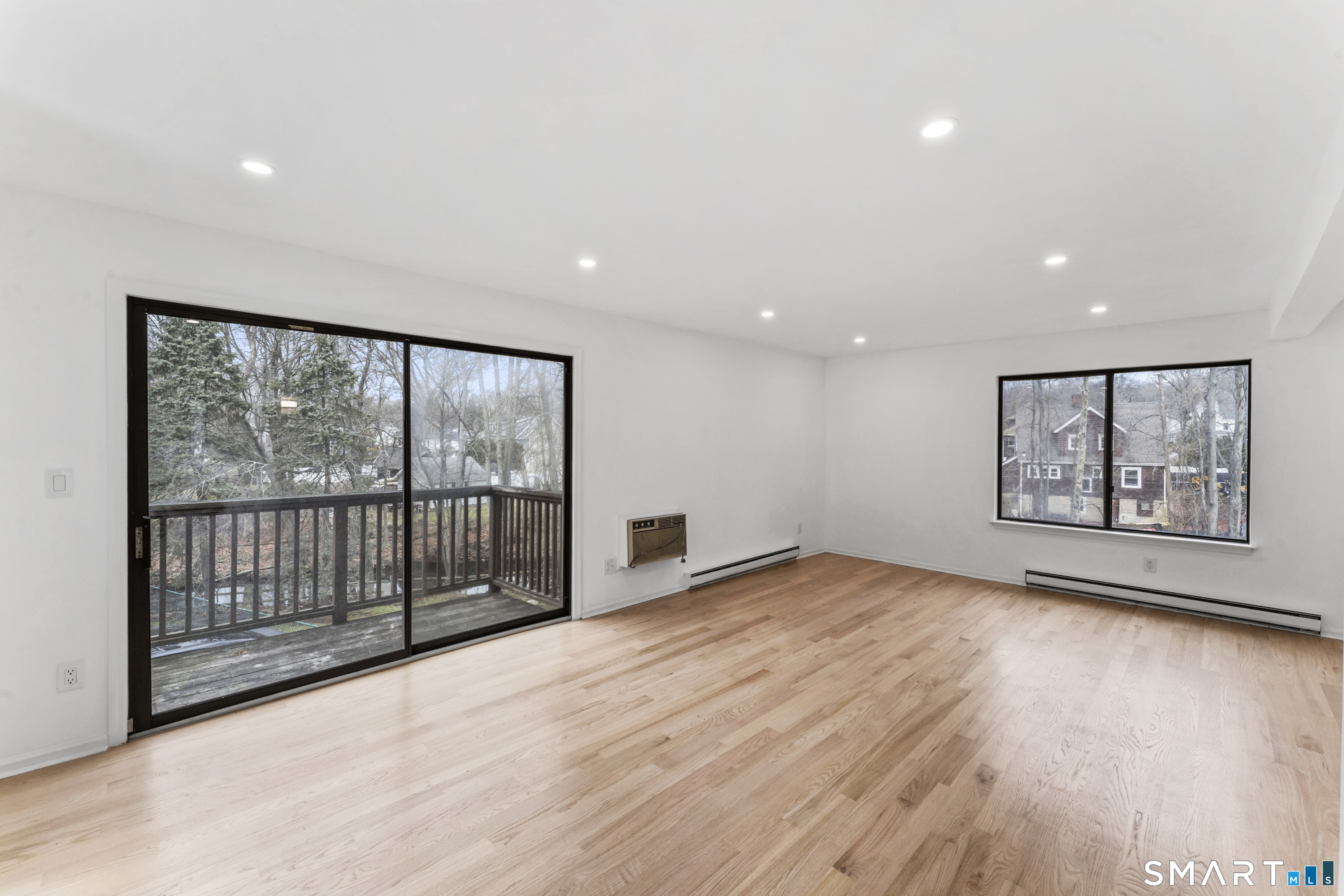100 Maple Tree Avenue, Unit 7 Stamford, CT 06906 - Photo 3 of 38 a view of an empty room with wooden floor and a window