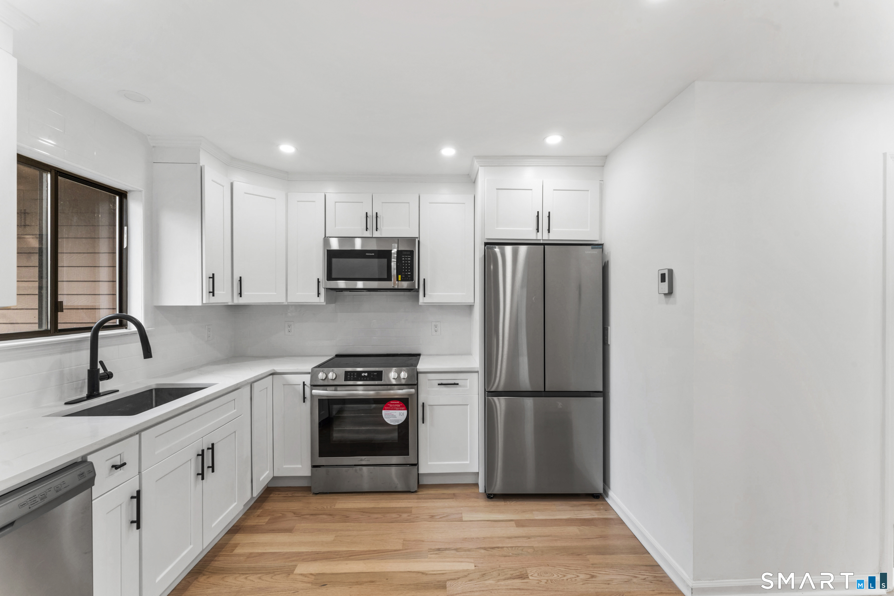 100 Maple Tree Avenue, Unit 7 Stamford, CT 06906 - Photo 9 of 38 a kitchen with stainless steel appliances granite countertop a refrigerator sink and cabinets
