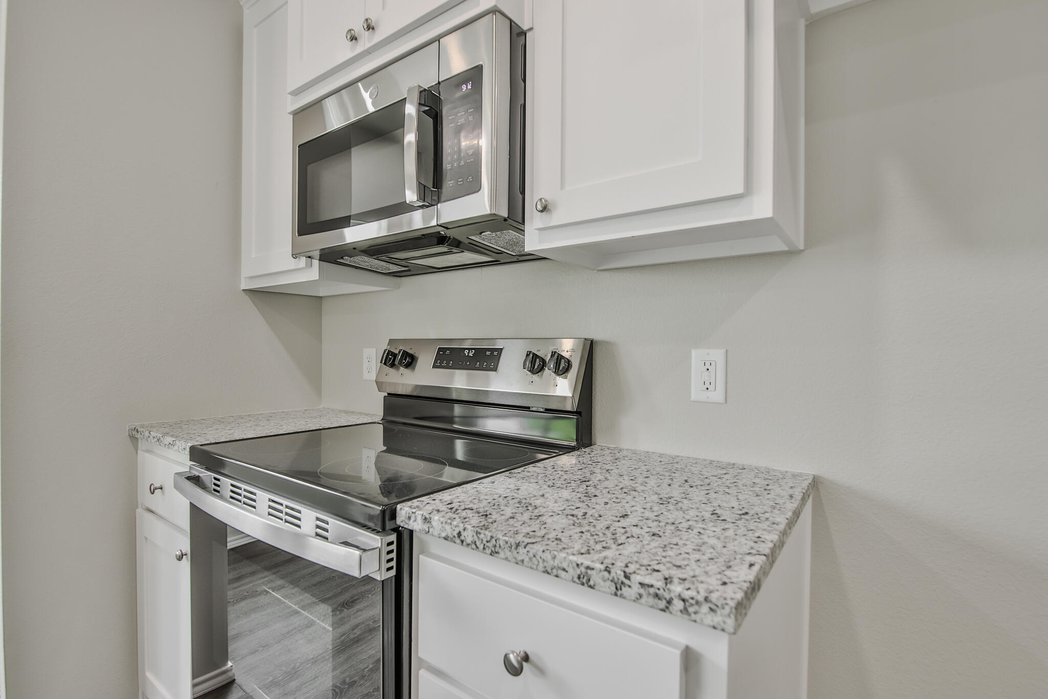 3115-3117 74th Street Lubbock, TX 79423 - Photo 11 of 37 a kitchen with stainless steel appliances granite countertop a stove microwave and sink