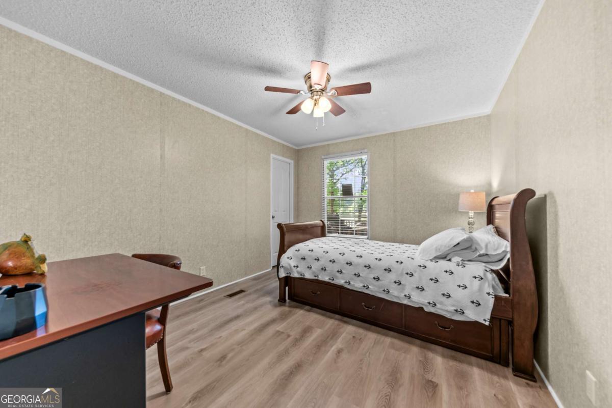 194 Phillips Road Eatonton, GA 31024 - Photo 28 of 57 a bedroom with a bed and a chandelier