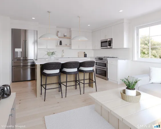 a kitchen with stainless steel appliances kitchen island granite countertop a table chairs microwave and cabinets