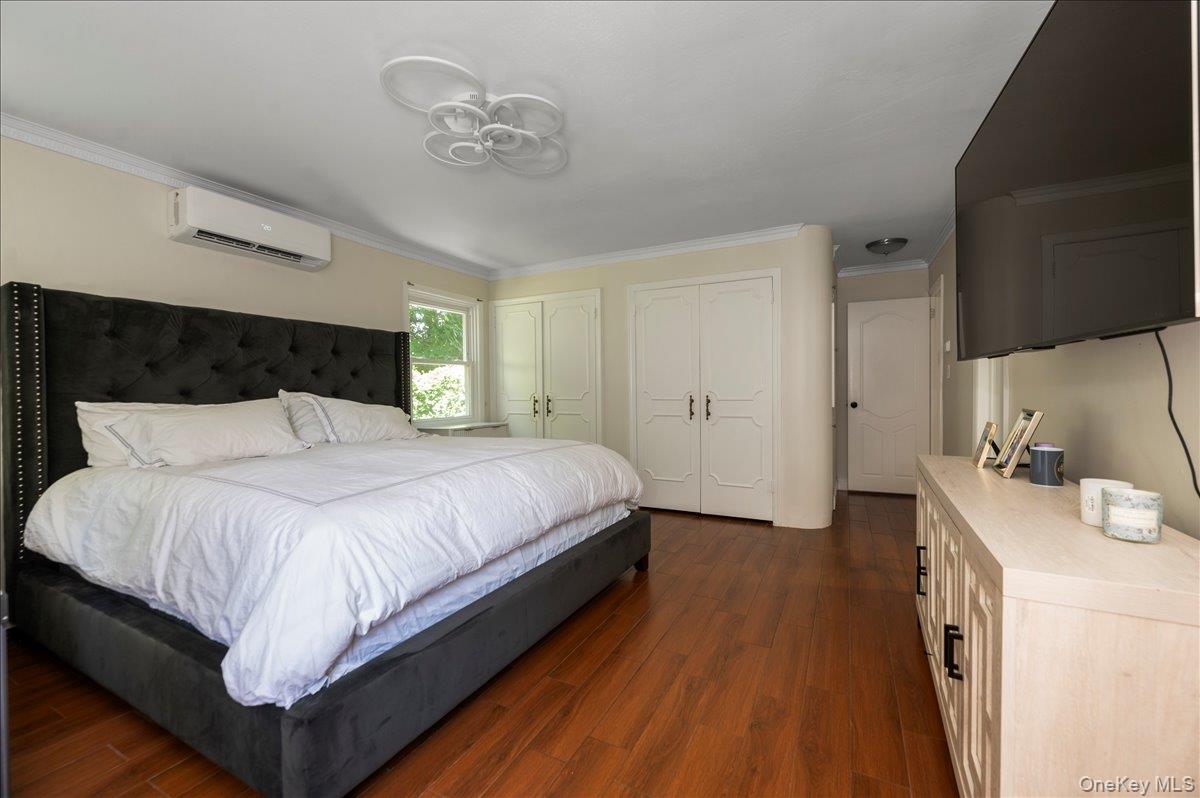 70 Longfellow Road Great Neck, NY 11023 - Photo 18 of 28 a bedroom with a bed and a chandelier