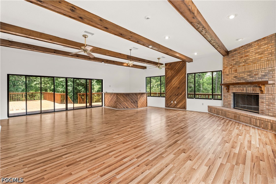 27255 Hickory Hill Road Brooksville, FL 34602 - Photo 19 of 50 an empty room with wooden floor fireplace and windows