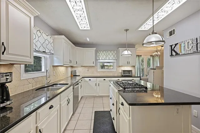a kitchen with stainless steel appliances a sink stove and refrigerator