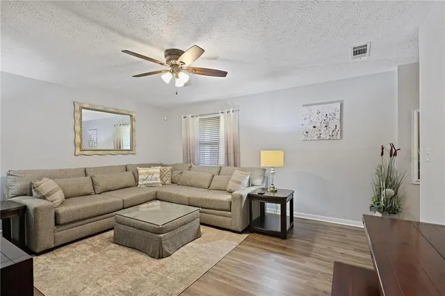 a living room with furniture and a wooden floor