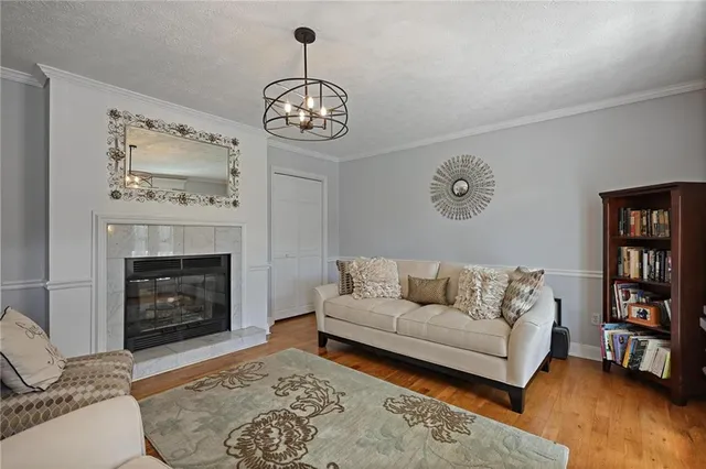 a living room with furniture a fireplace and a chandelier