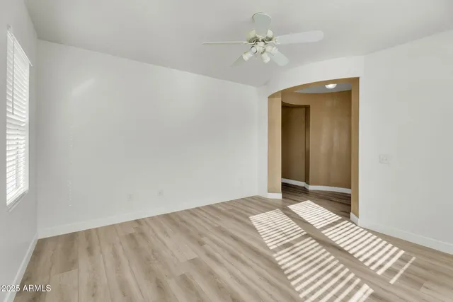 a kitchen with stainless steel appliances a refrigerator a sink a stove and white cabinets with wooden floor