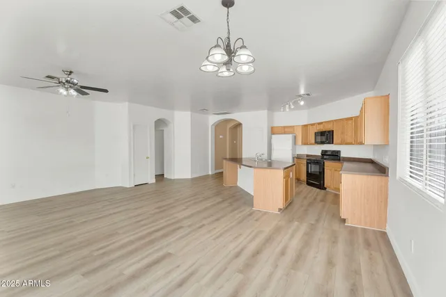 a kitchen with stainless steel appliances granite countertop a sink a stove and cabinets
