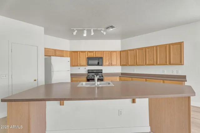 an empty room with wooden floor and a ceiling fan