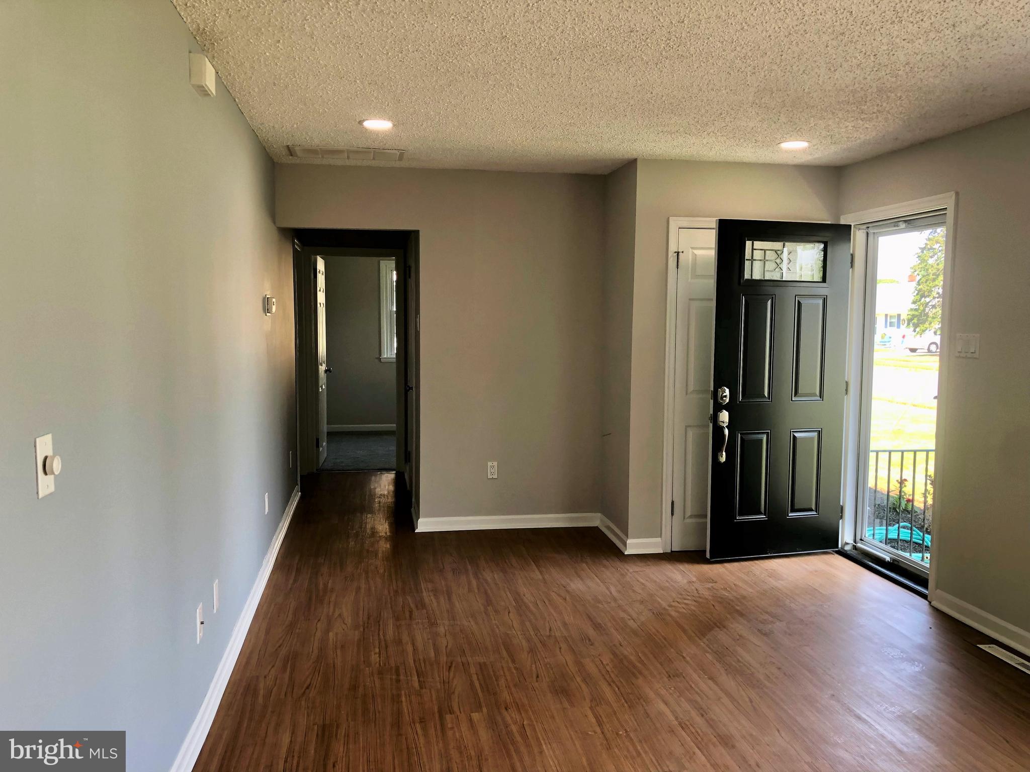404 Flanders Road Bellmawr, NJ 08031 - Photo 4 of 19 an empty room with wooden floor and windows