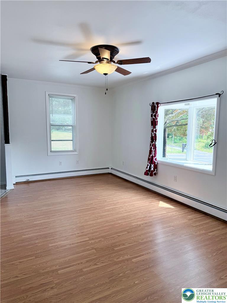 5540 Main Street Whitehall, PA 18052 - Photo 20 of 53 Well-lit living area featuring rich hardwood flooring and a stylish ceiling fan.
