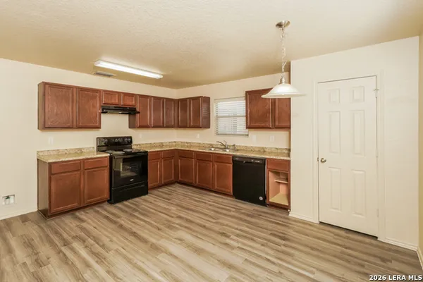a kitchen with stainless steel appliances granite countertop a sink counter space cabinets and a wooden floor
