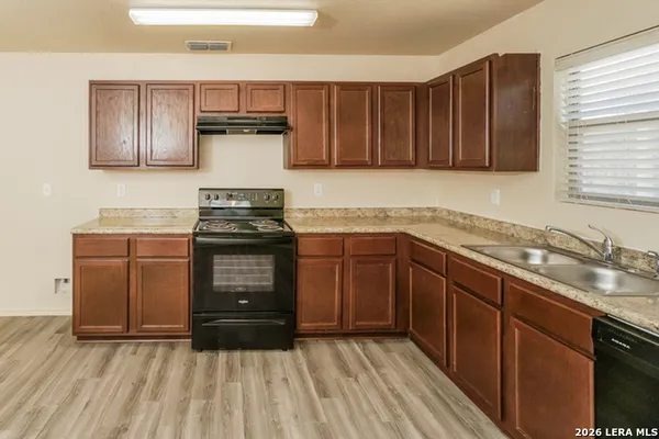 a kitchen with granite countertop a stove and a sink