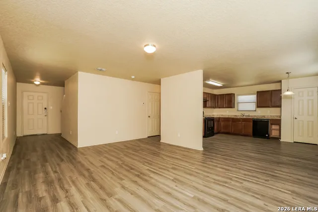 a view of a kitchen with kitchen island wooden floor stainless steel appliances and cabinets