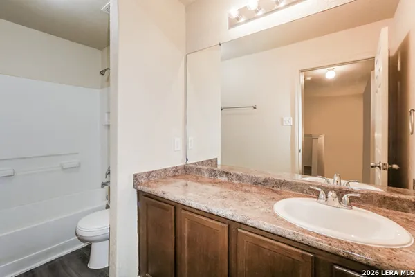 a bathroom with a granite countertop sink toilet and shower