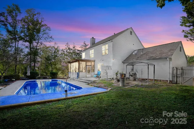 a view of backyard of house with outdoor seating and green space