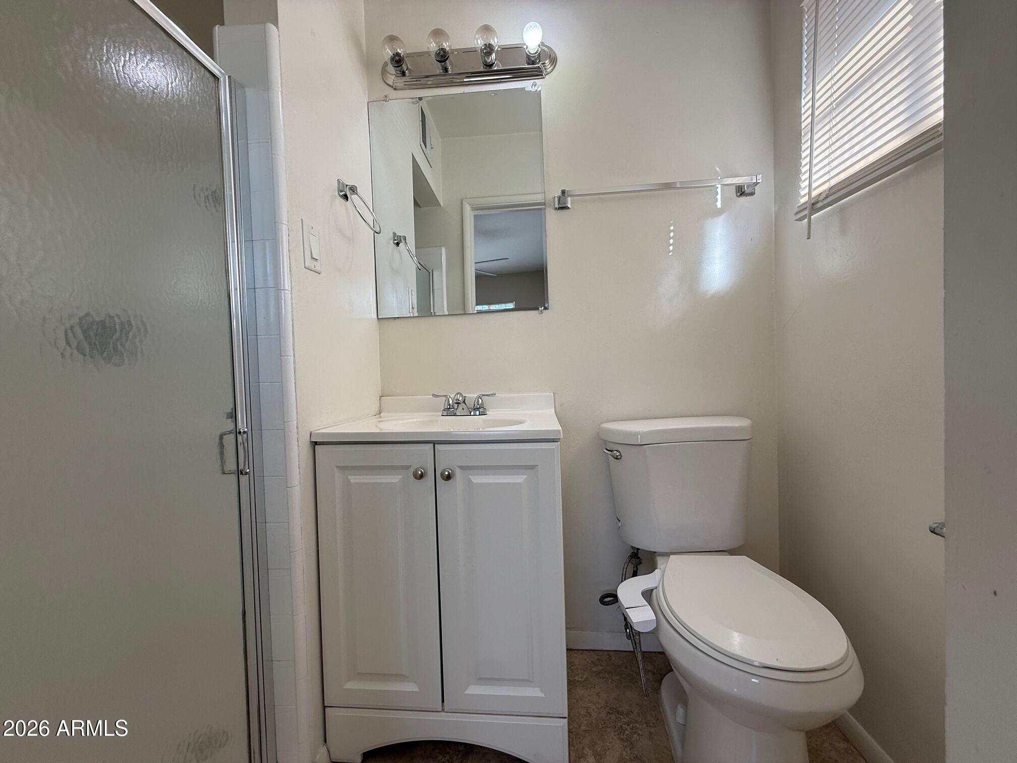 4447 East Almeria Road Phoenix, AZ 85008 - Photo 7 of 9 a white toilet sitting next to a bathroom sink