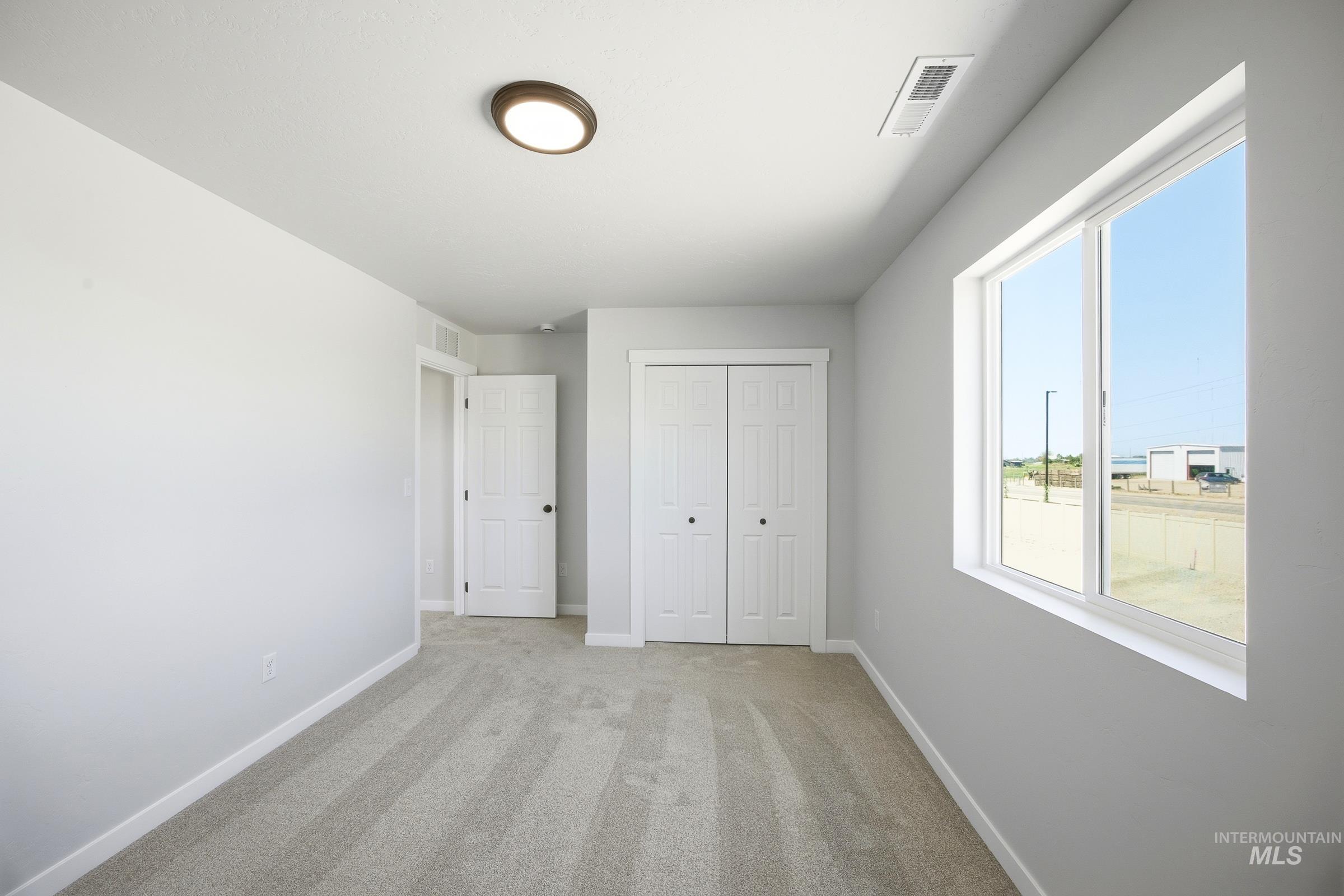 12841 Decatur Street Nampa, ID 83651 - Photo 24 of 30 Carpeted room featuring a white bi-fold closet, a single window, and a flush-mount ceiling light