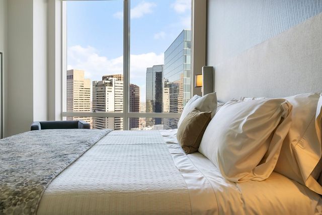 a bed sitting in a bedroom next to a window