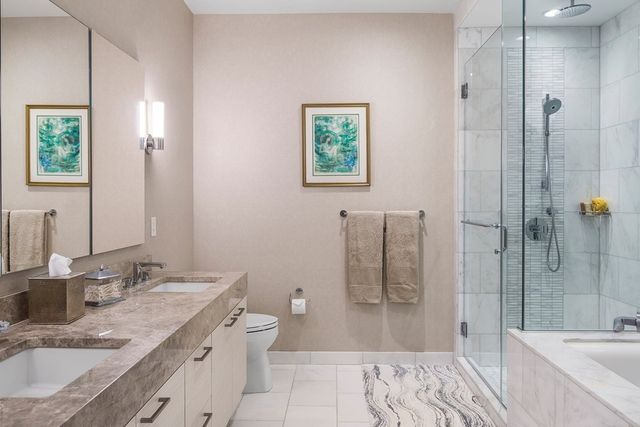 a bathroom with a granite countertop sink a toilet a mirror and shower