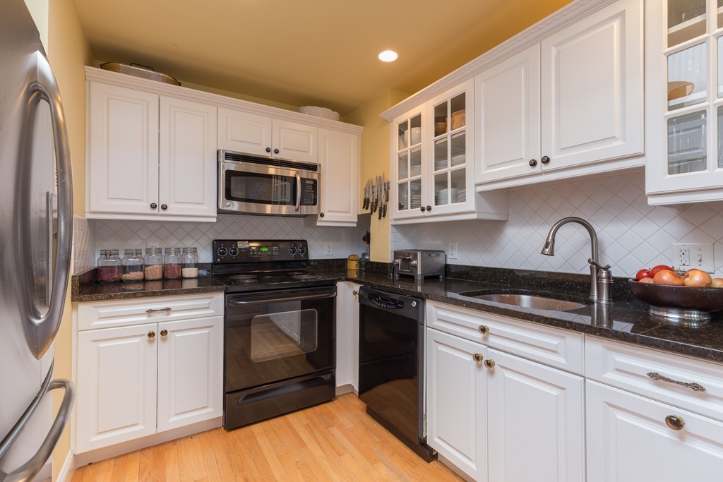 37 Bay State Road, Unit 6 Boston, MA 02215 - Photo 11 of 25 a kitchen with stainless steel appliances granite countertop a stove a sink and a microwave