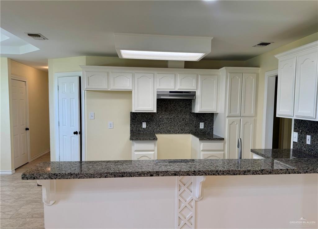 2207 Turtle Court Mission, TX 78572 - Photo 7 of 22 a kitchen with granite countertop a sink a stove and a granite counter top