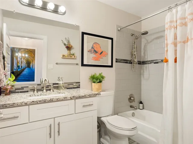 a bathroom with a granite countertop sink a toilet and shower
