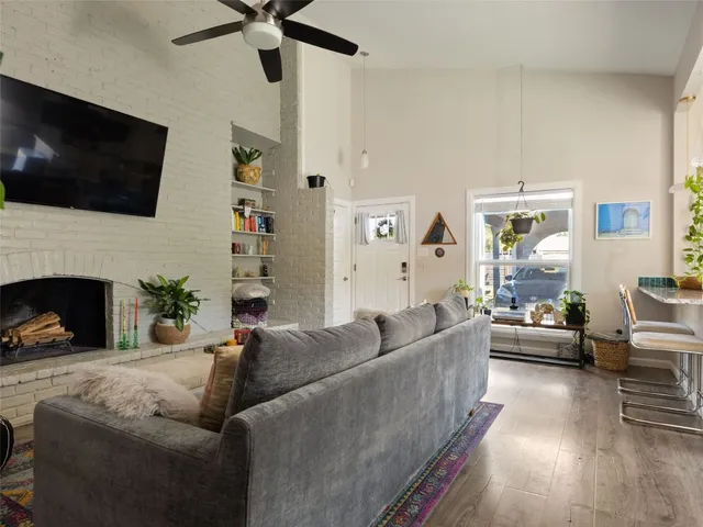 a living room with furniture a flat screen tv and a fireplace