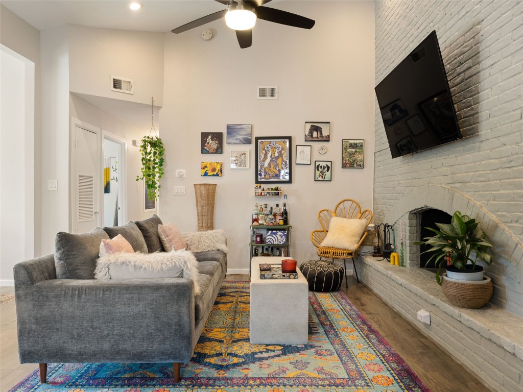 1307 East St Johns Avenue, Unit B Austin, TX 78752 - Photo 6 of 27 a living room with furniture a flat screen tv and a fireplace