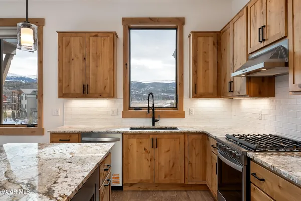a kitchen with granite countertop a sink stove and cabinets