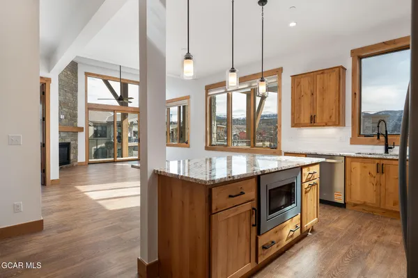 a kitchen with granite countertop a stove a sink and a wooden floors