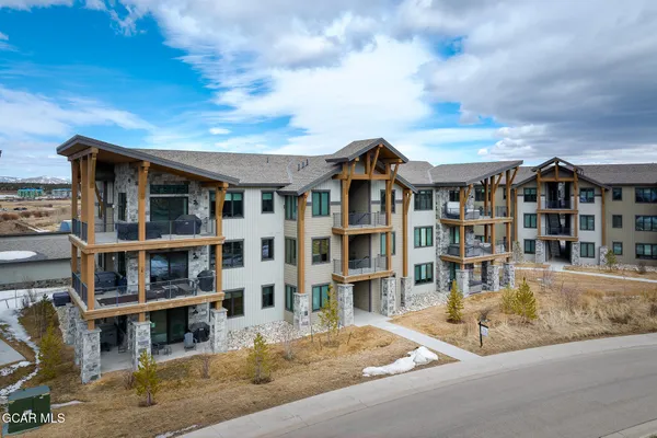 a view of a big house with wooden fence