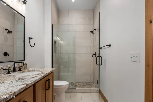 a bathroom with a granite countertop sink toilet and shower