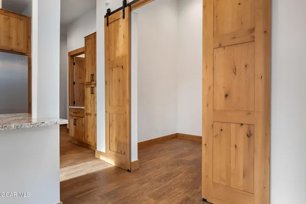an empty room with wooden floor and a bathroom