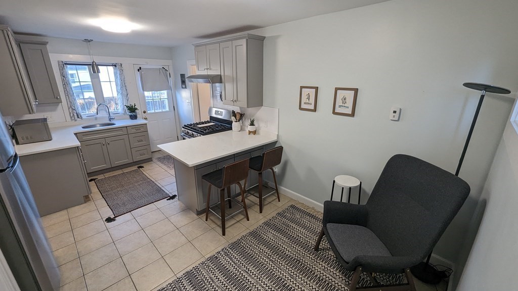 975 Chestnut Street, Unit R Newton, MA 02464 - Photo 1 of 8 a view of a workspace with furniture and a couch
