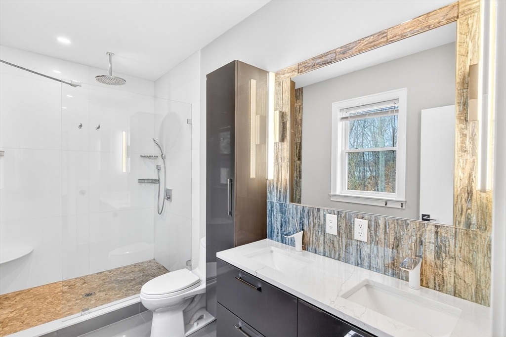 93 Alden Street Dedham, MA 02026 - Photo 14 of 41 a bathroom with a sink a toilet a large mirror and shower