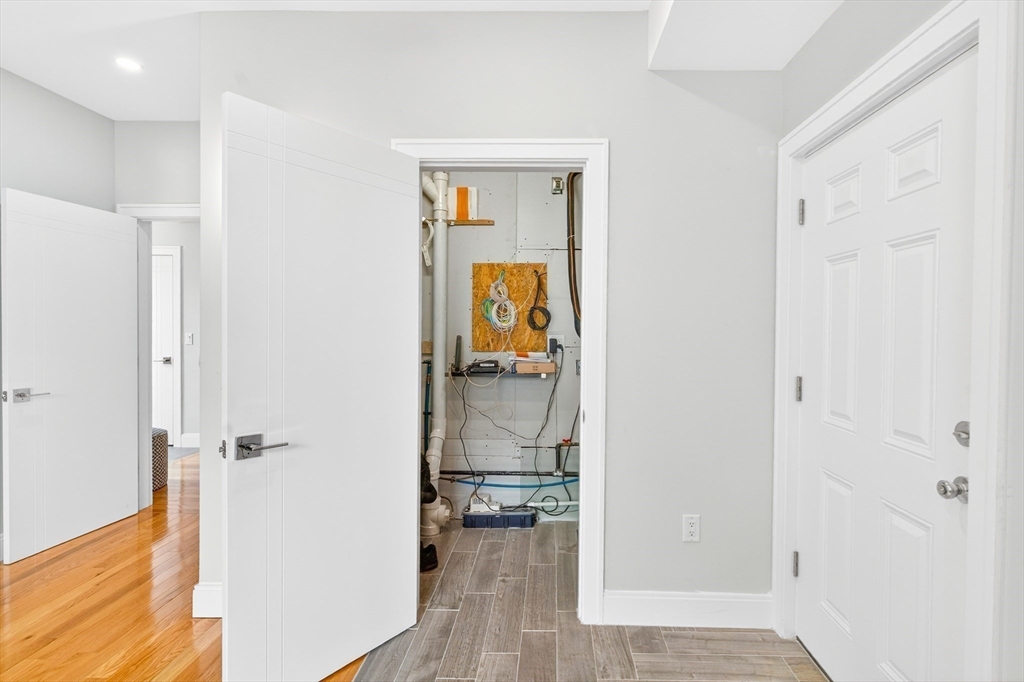 93 Alden Street Dedham, MA 02026 - Photo 17 of 41 a view of a hallway with wooden floor and a bathroom