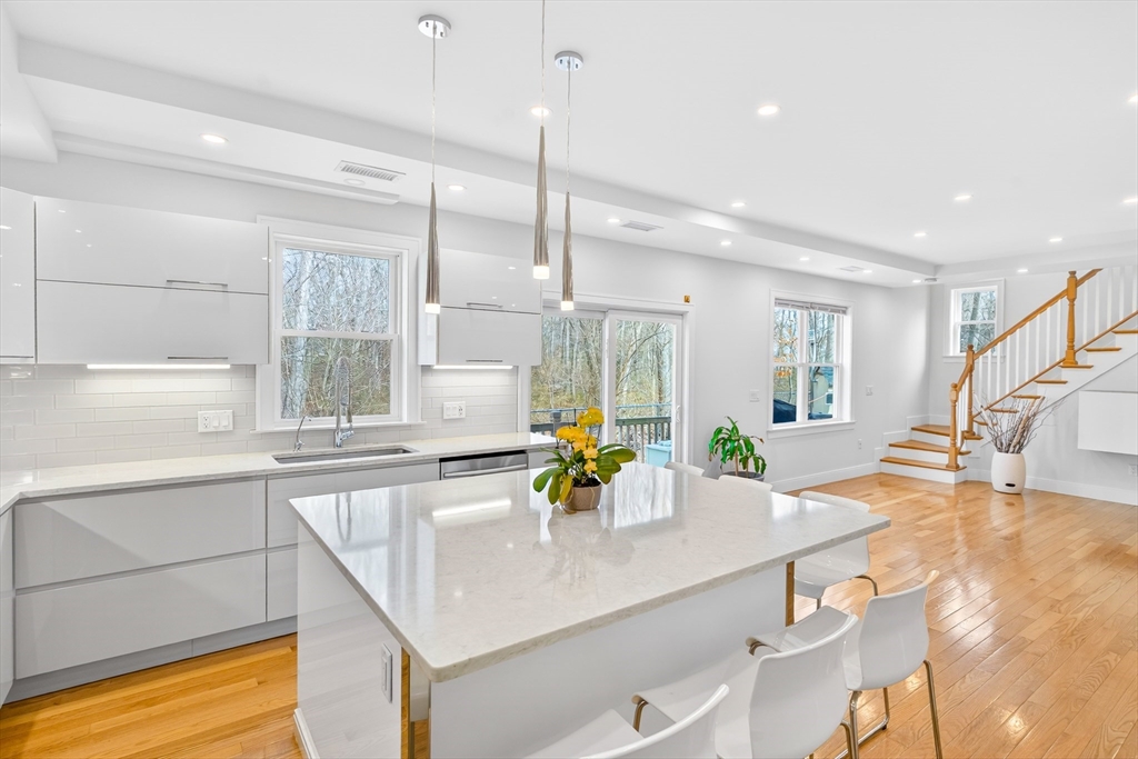 93 Alden Street Dedham, MA 02026 - Photo 3 of 41 a kitchen with kitchen island a sink dining table and chairs