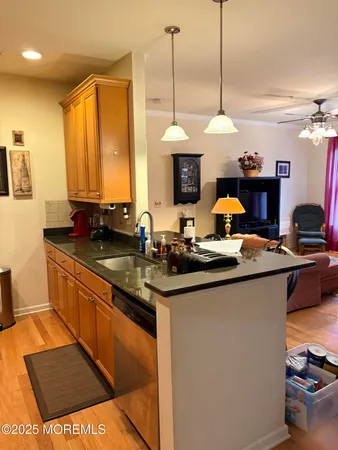 a kitchen with stainless steel appliances granite countertop a sink a stove and a wooden floors