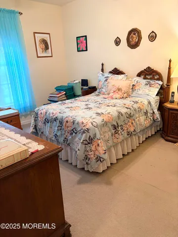 a bedroom with a bed and a lamp on dresser