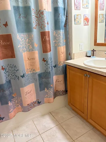 a bathroom with a sink mirror and shower