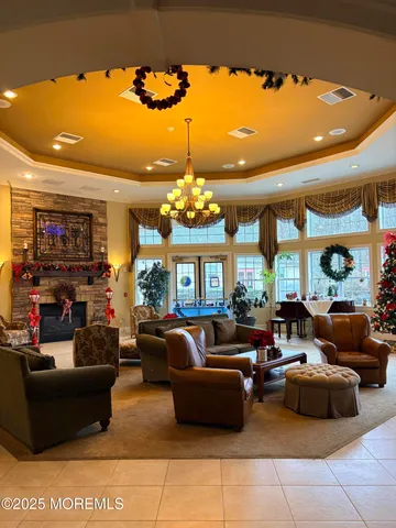 a living room with furniture a chandelier and a large window