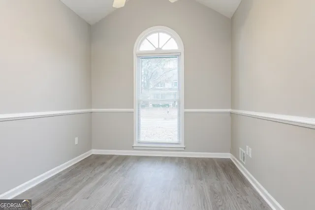 an empty room with wooden floor and window
